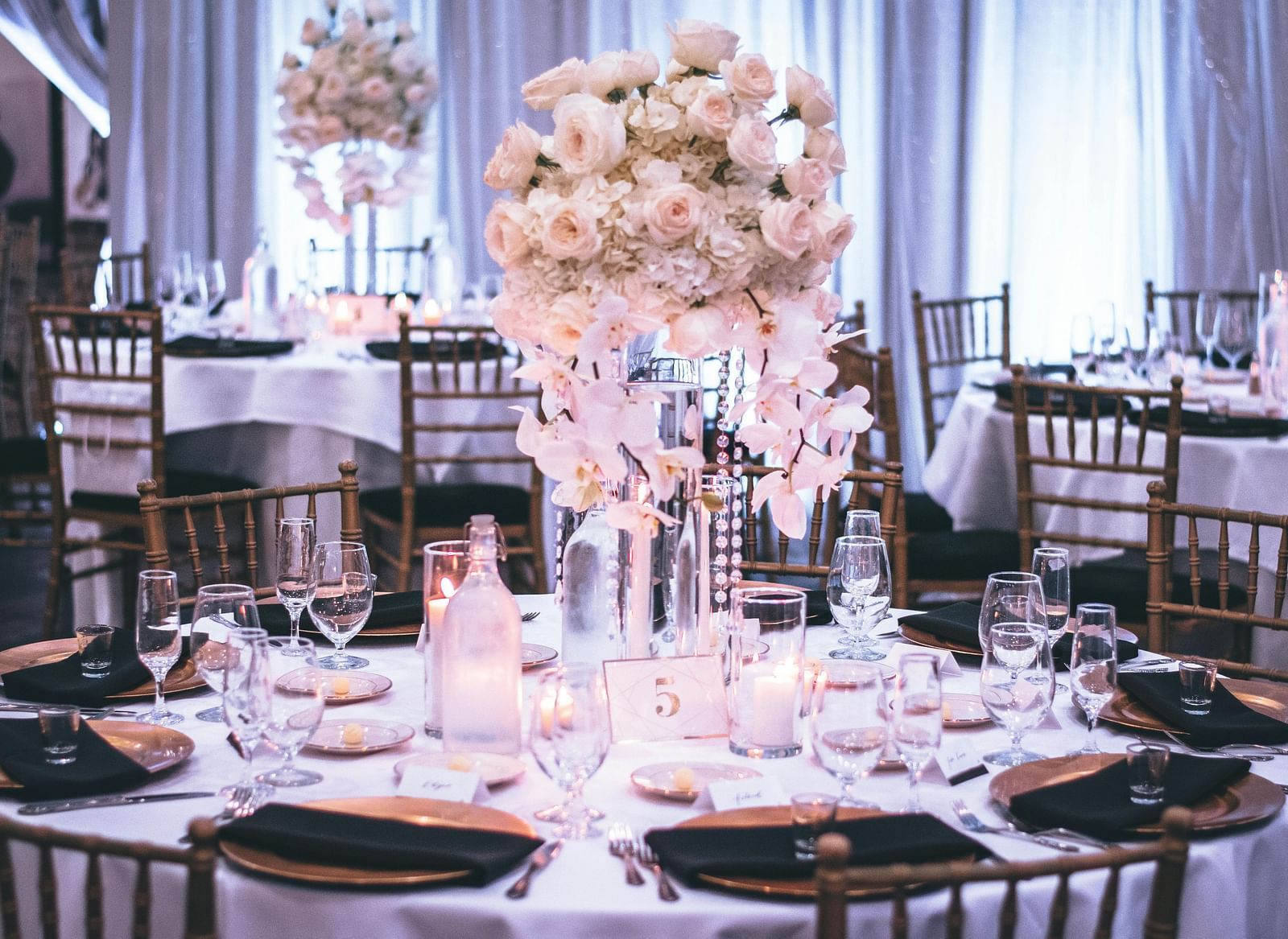 A beautifully decorated table for a special event, featuring a large floral arrangement.